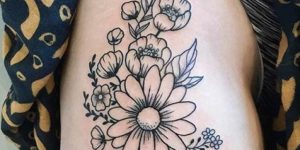 tatuagem feminina de flores na coxa