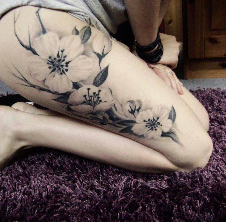 tatuagem feminina de flores na coxa