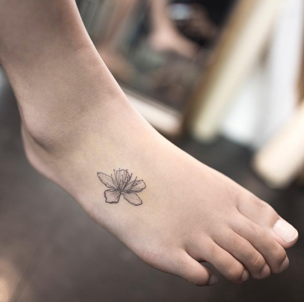 tatuagem feminina de traços finos no pé