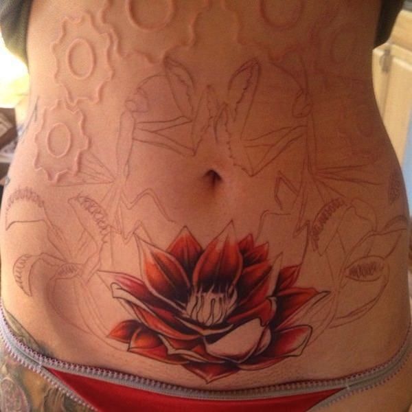 tatuagem feminina na barriga de flor de lótus