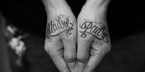 Ideais de tatuagens para homenagear a família. Foto mãos tatuadas com os nomes de madre e padre