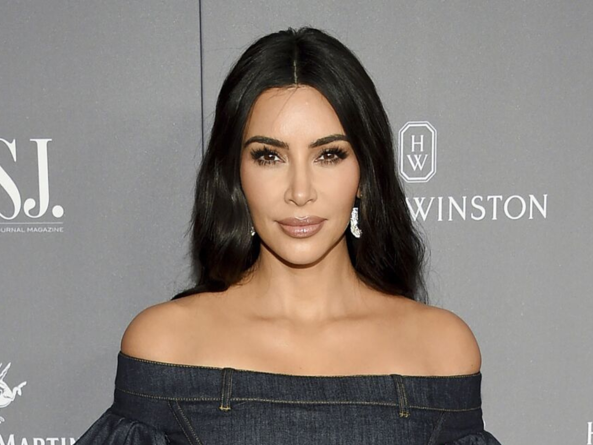 Estilos de Roupas que a Kim Kardashian usa. Foto mostra Kim Kardashian usando posando para foto com look escuro e maquiagem de olhos esfumados e lábios neutros.