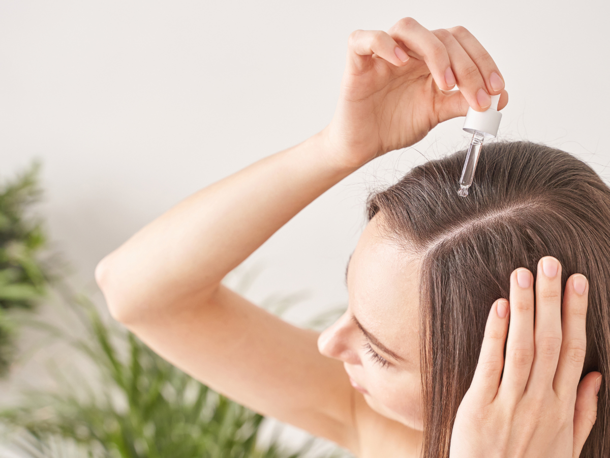 Hair Oiling. Foto mulher passando óleo na raiz do cabelo