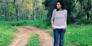 Peças de roupas que combinam com mulheres de 40 anos. Foto mulher branca com camiseta listrada em preto e branco e calça jeans