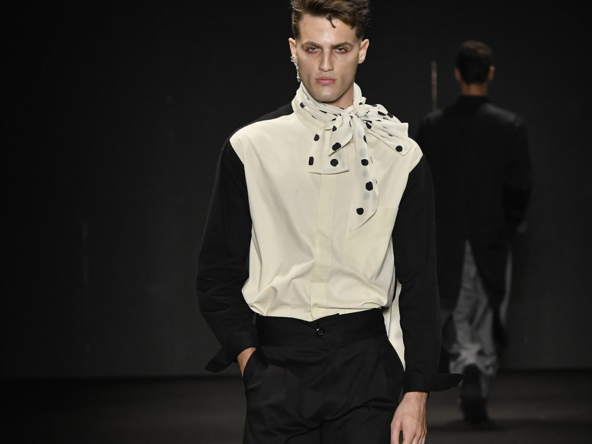 Looks com camisa e alfaiataria inspiradas em Igor Danona. Foto mostra um modelo na passarela vestindo camisa social branca e preta com colarinho.