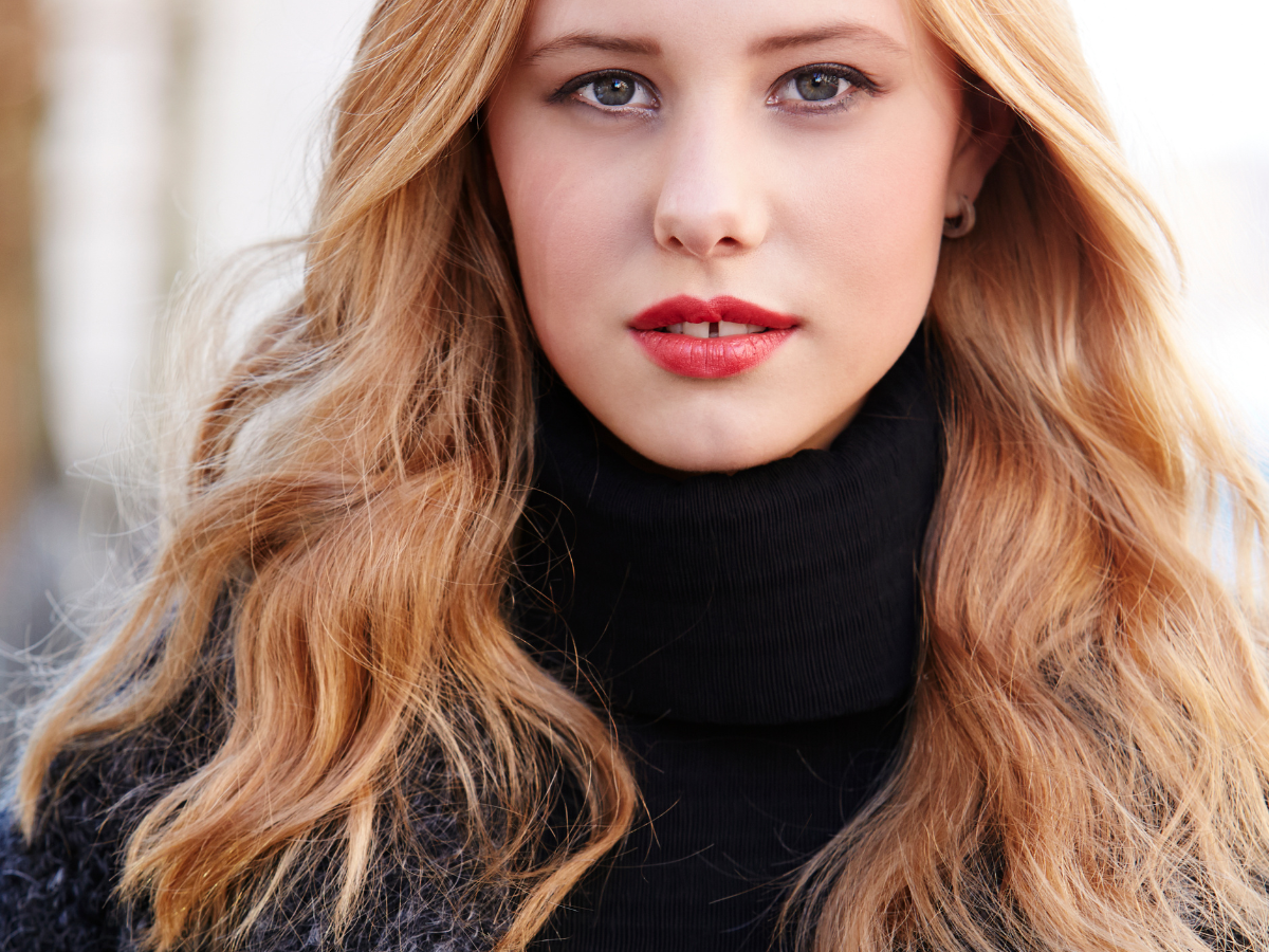 Strawberry blonde. Foto mulher com cabelos loiros avermelhados e batom vermelho.