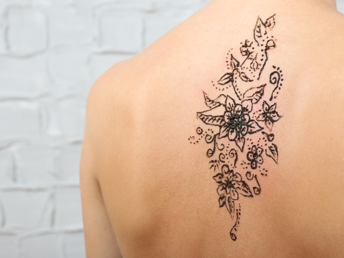 Tatuagens para as costas. Foto traz uma tatuagem nas costas em formato de flores.