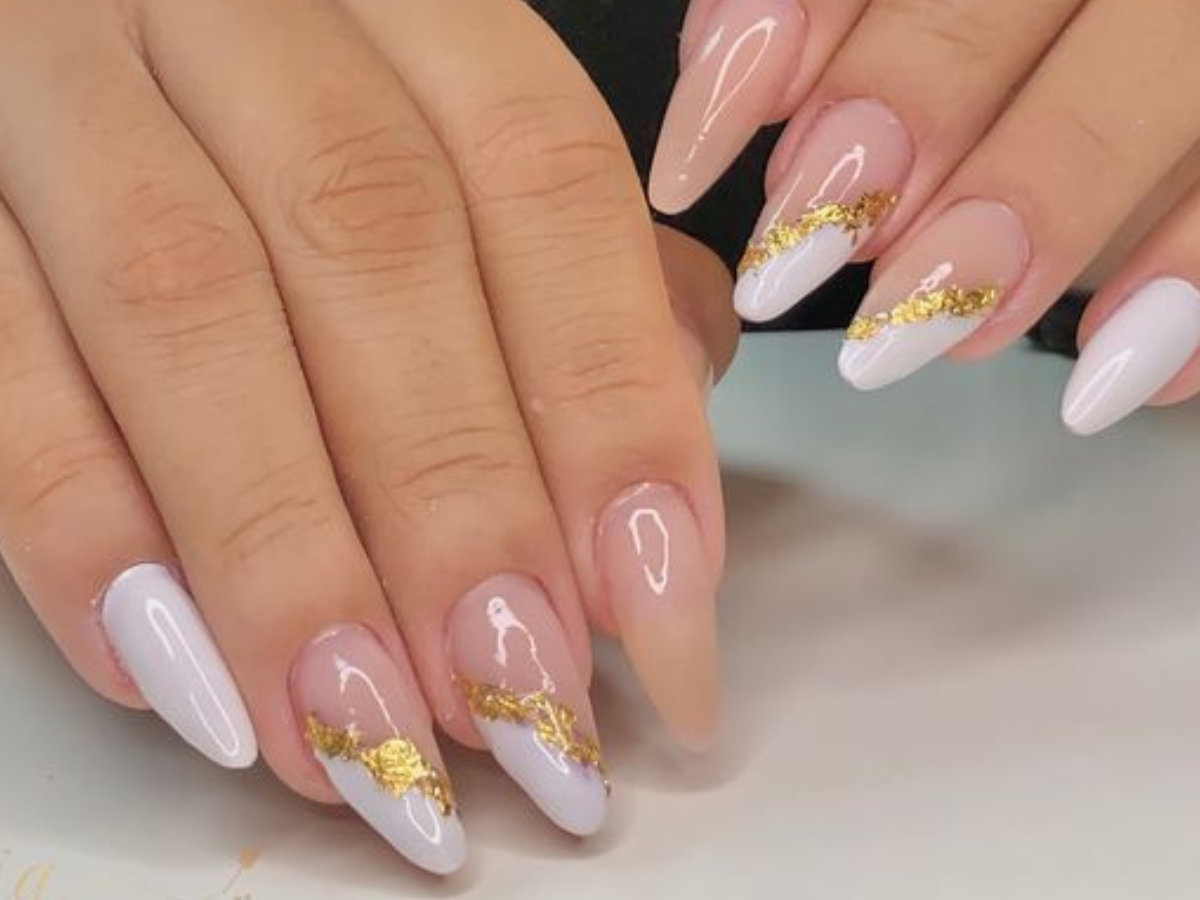 unhas com cores branco e dourado