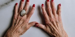 mãos mais velhas com esmalte vermelho