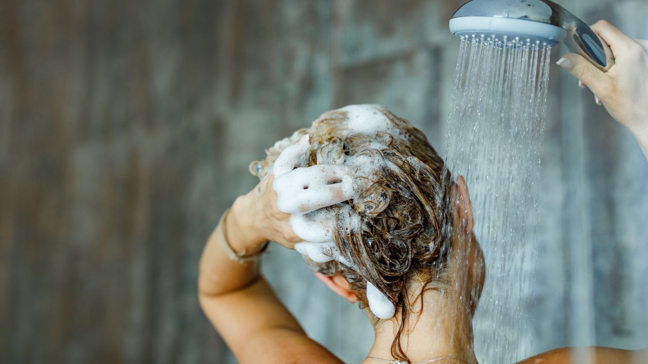 mulher lavando o cabelo com ducha