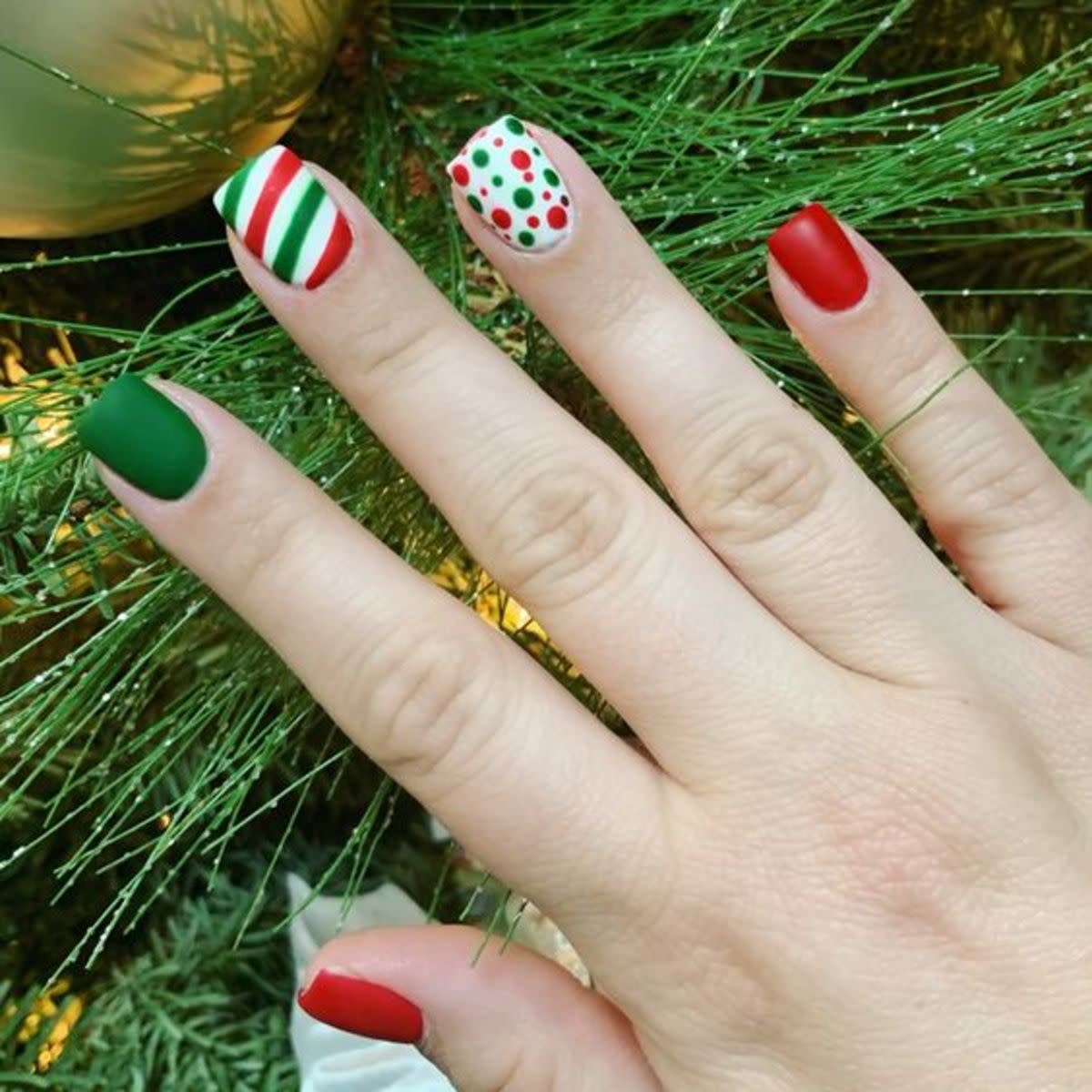 unhas curtas com listras e bolinhas em cores de natal